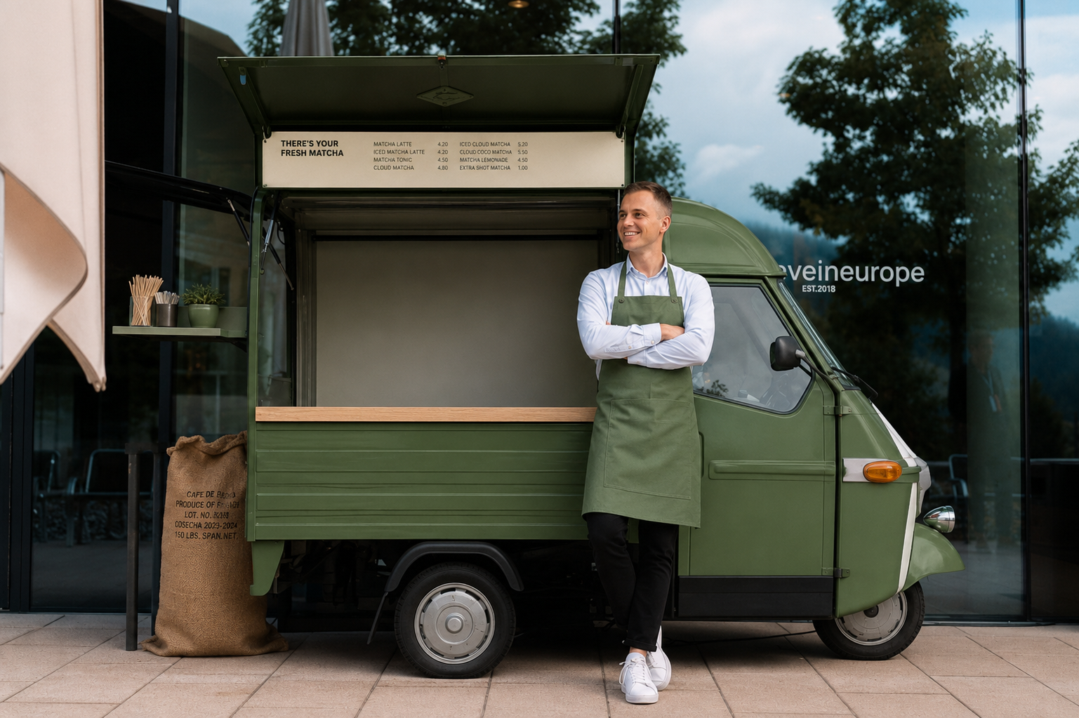 Matcha Mobil Ape mit geöffnetem Verkaufsfenster und Matcharista